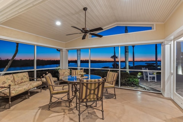 sunroom featuring lofted ceiling, a ceiling fan, and a water view