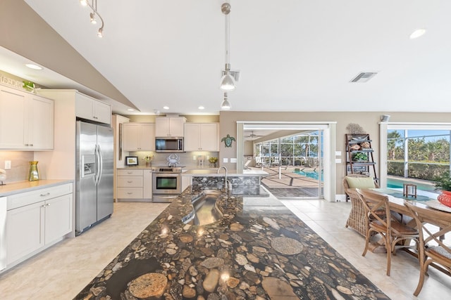 kitchen with tasteful backsplash, visible vents, stainless steel appliances, and lofted ceiling