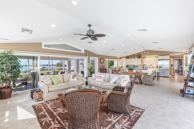 living room featuring visible vents, ceiling fan, and vaulted ceiling