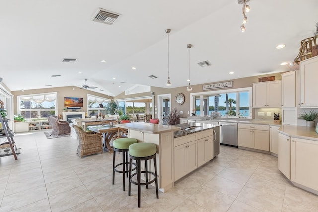 kitchen featuring stainless steel dishwasher, lofted ceiling, and visible vents