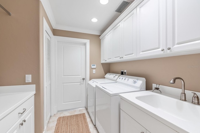 laundry area with visible vents, a sink, washer and dryer, cabinet space, and light tile patterned floors