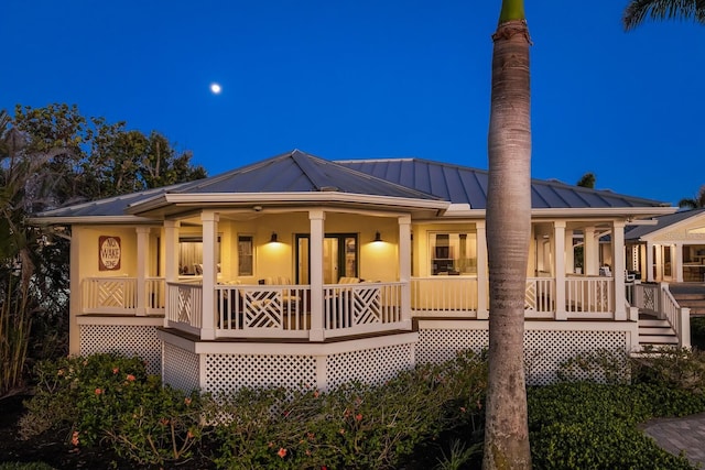 rear view of property featuring covered porch, metal roof, and a standing seam roof