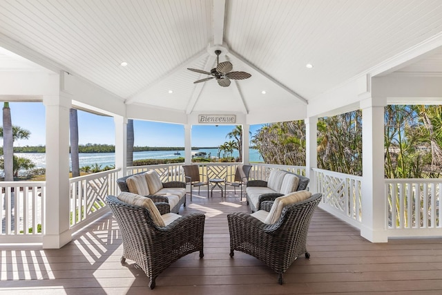 deck featuring ceiling fan, a gazebo, a water view, and an outdoor hangout area