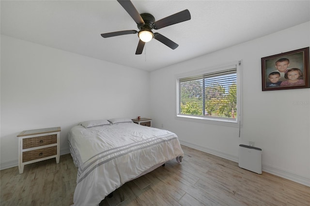 bedroom featuring a ceiling fan, wood finished floors, and baseboards