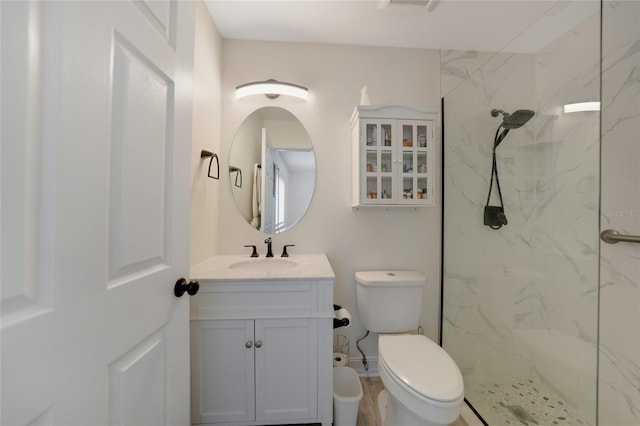 full bathroom featuring a marble finish shower, toilet, and vanity