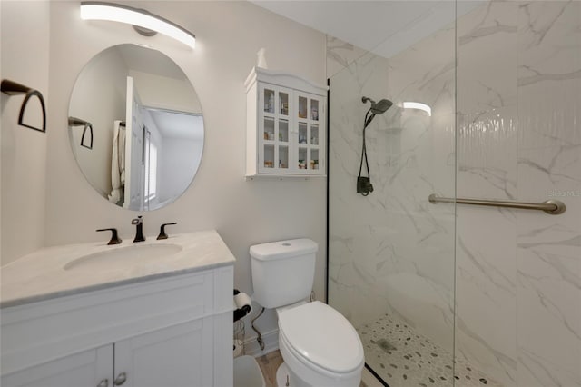 full bath with vanity, toilet, and a marble finish shower