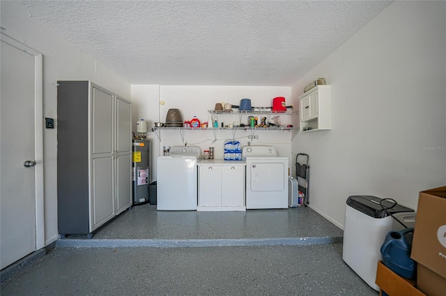 laundry room featuring a textured ceiling, cabinet space, water heater, and washer and clothes dryer