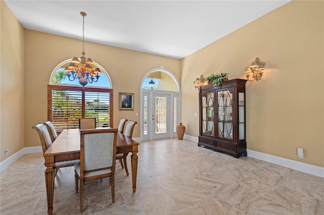 dining space featuring a notable chandelier and baseboards