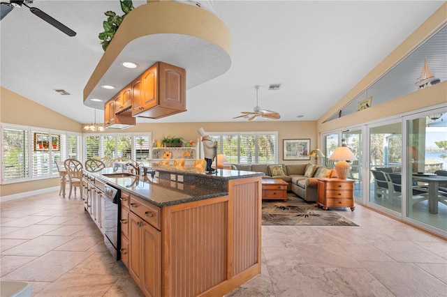 kitchen with dishwashing machine, dark stone countertops, visible vents, a sink, and ceiling fan with notable chandelier