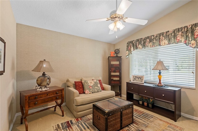 carpeted living area featuring a ceiling fan, baseboards, and vaulted ceiling