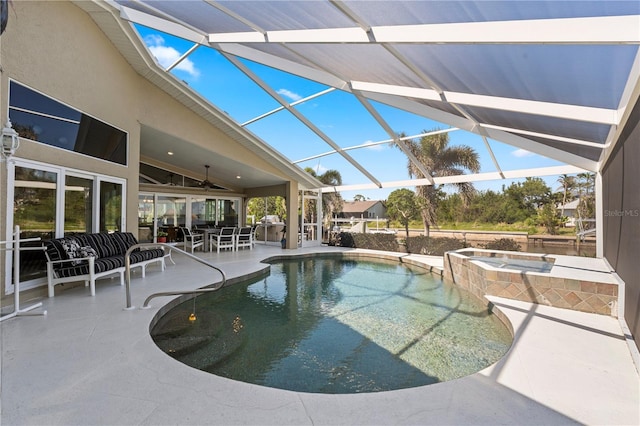 view of swimming pool with outdoor dining space, a patio, a pool with connected hot tub, ceiling fan, and a lanai