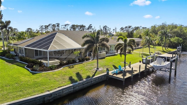 rear view of property with a water view, a patio, a yard, glass enclosure, and boat lift