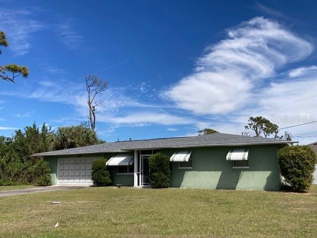 view of front of house with a garage, driveway, a front lawn, and stucco siding