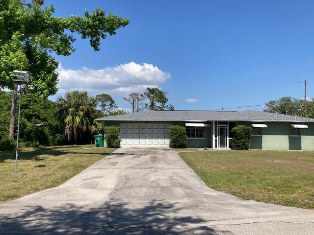 view of front facade with an attached garage, concrete driveway, and a front yard