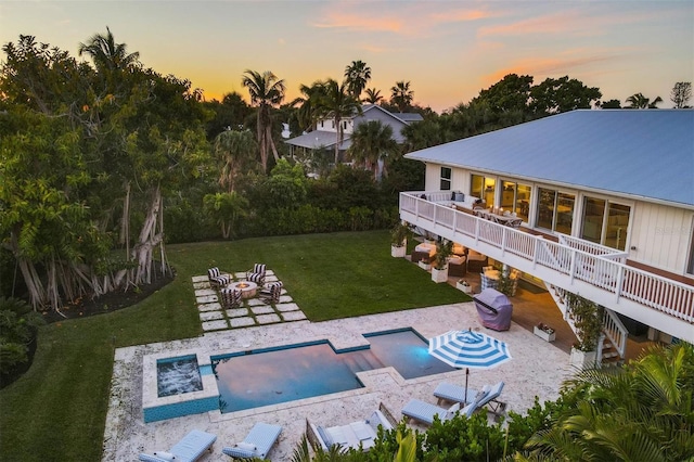 rear view of property with a lawn, a patio, a fire pit, a wooden deck, and stairs