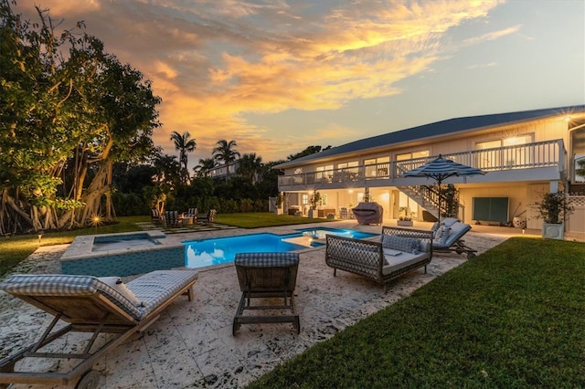 outdoor pool with a patio, a lawn, an in ground hot tub, and stairs