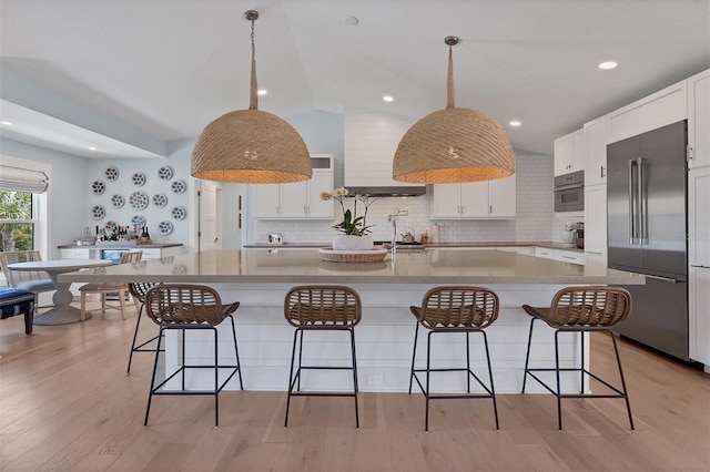 kitchen featuring white cabinetry, light wood finished floors, high end fridge, and wall oven