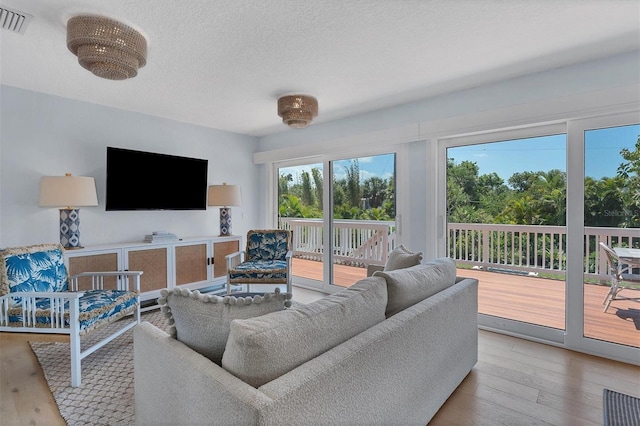 living room with visible vents, wood-type flooring, and a textured ceiling