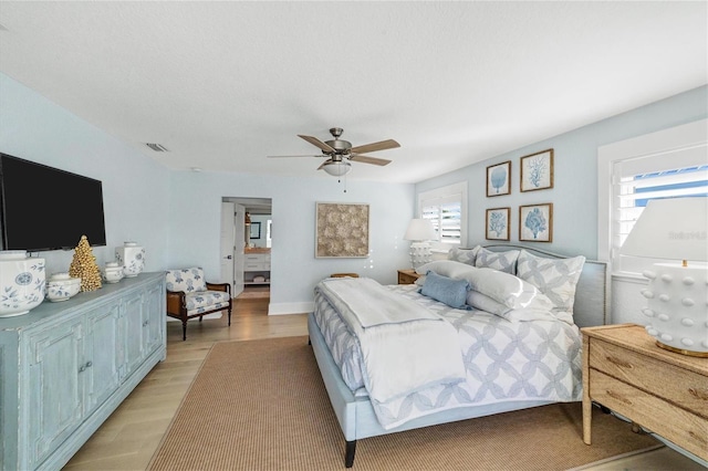 bedroom featuring visible vents, baseboards, light wood-type flooring, and ceiling fan