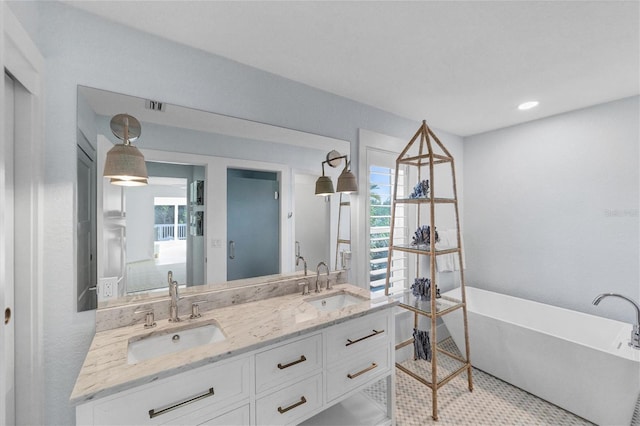 bathroom featuring a sink, plenty of natural light, and a soaking tub