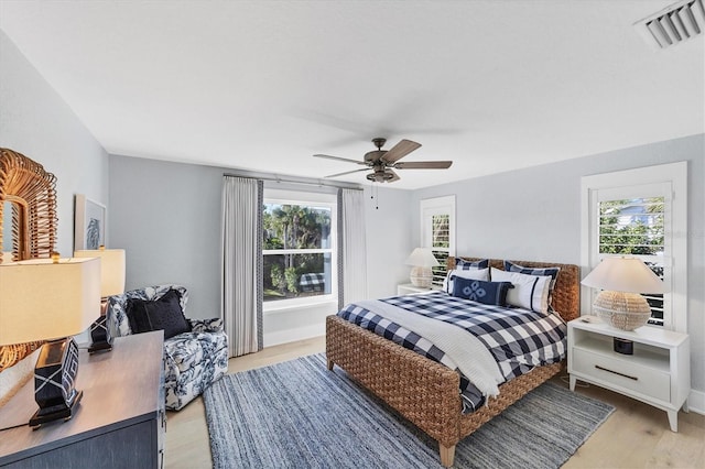 bedroom with baseboards, visible vents, light wood finished floors, and ceiling fan