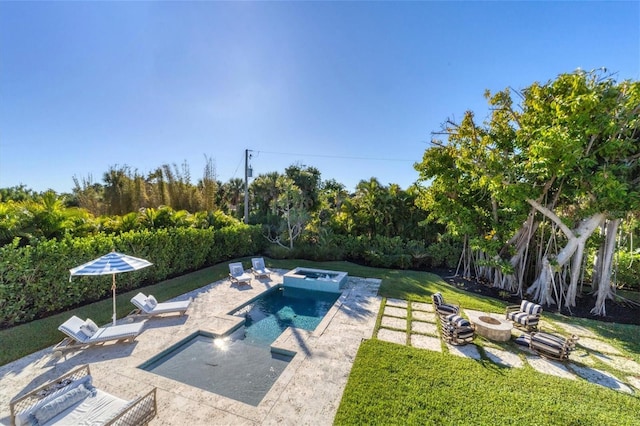 view of swimming pool with a fenced in pool, an outdoor fire pit, a yard, a patio area, and an in ground hot tub