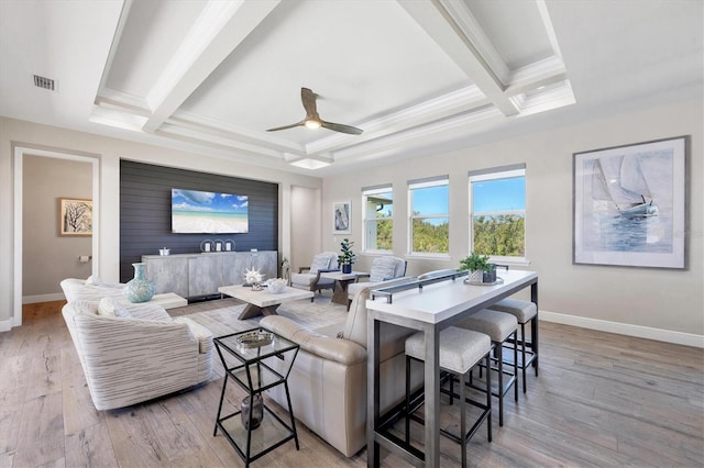 living room featuring visible vents, baseboards, beamed ceiling, and light wood finished floors