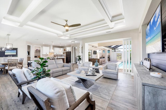 living area with beam ceiling, ceiling fan, coffered ceiling, and light wood-style floors