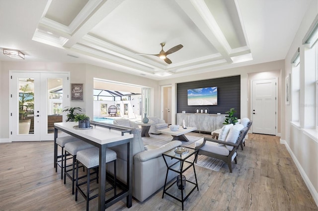 living room with light wood finished floors, ceiling fan, french doors, and baseboards