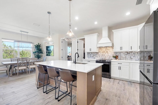 kitchen with visible vents, a sink, backsplash, stainless steel electric range, and custom exhaust hood