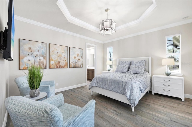 bedroom with a raised ceiling, crown molding, and wood finished floors