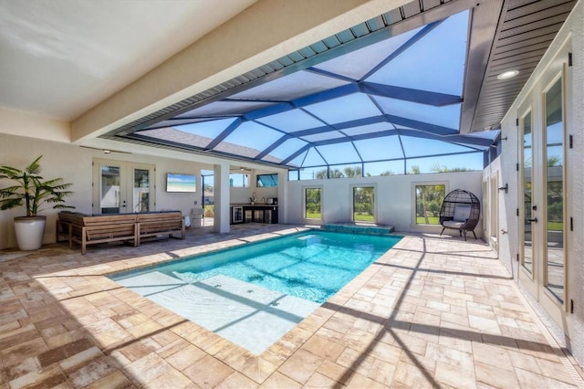 outdoor pool with outdoor lounge area, a patio, french doors, and a lanai