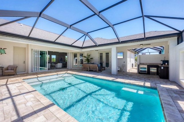 pool featuring a patio area, an outdoor kitchen, french doors, and a lanai