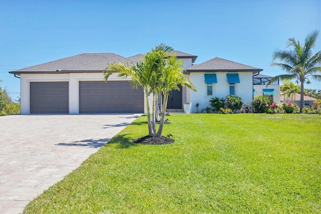 view of front facade featuring decorative driveway, a front yard, an attached garage, and stucco siding