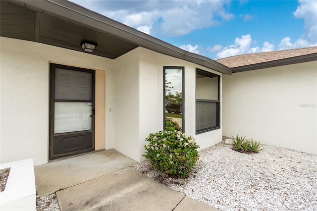 entrance to property featuring stucco siding