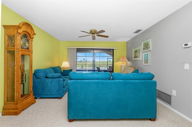 carpeted living room featuring visible vents, baseboards, and a ceiling fan