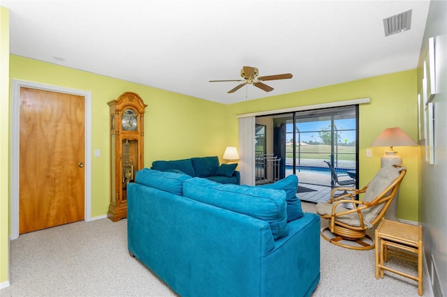 living area featuring visible vents, baseboards, ceiling fan, and carpet flooring