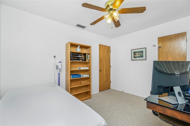 carpeted bedroom with baseboards, visible vents, a textured ceiling, and a ceiling fan