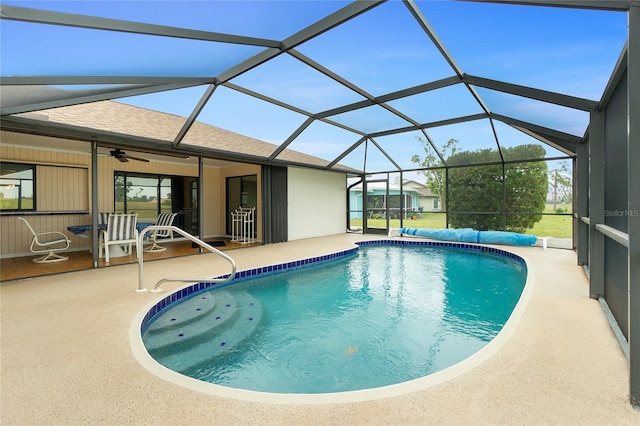 view of swimming pool with a covered pool, glass enclosure, and a patio