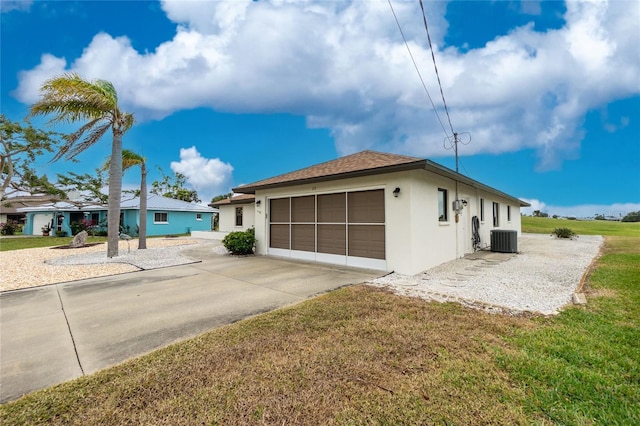 view of side of property with cooling unit, a lawn, driveway, and stucco siding