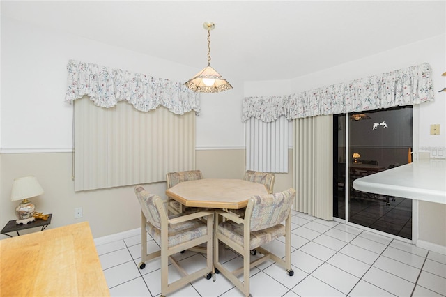 tiled dining space featuring baseboards