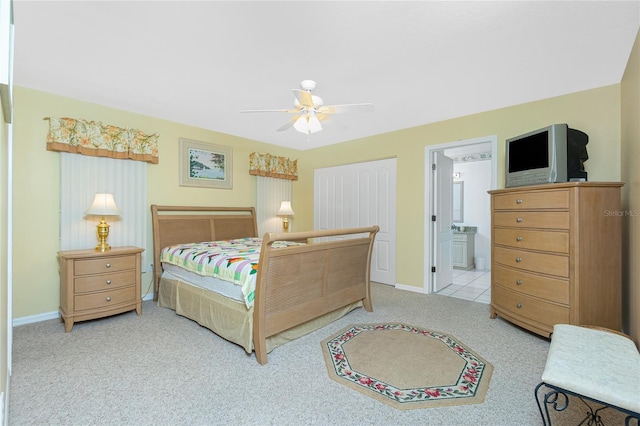 bedroom with baseboards, ceiling fan, ensuite bath, and carpet