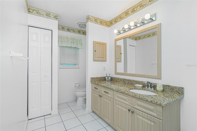 bathroom with a closet, tile patterned flooring, toilet, and vanity