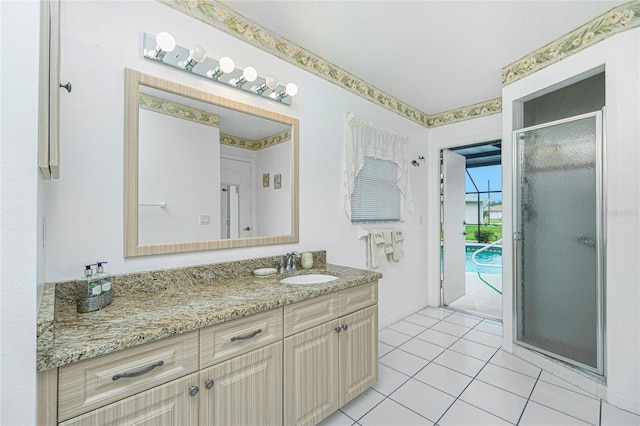 bathroom featuring vanity, a shower stall, baseboards, and tile patterned flooring