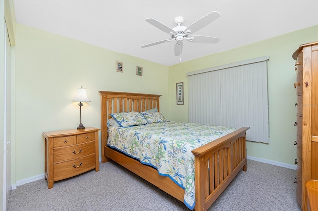 bedroom with a ceiling fan, baseboards, and light carpet