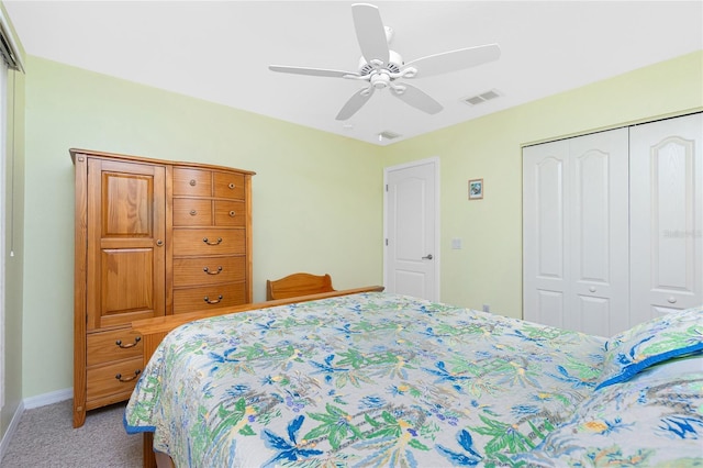 carpeted bedroom with a closet, baseboards, visible vents, and ceiling fan