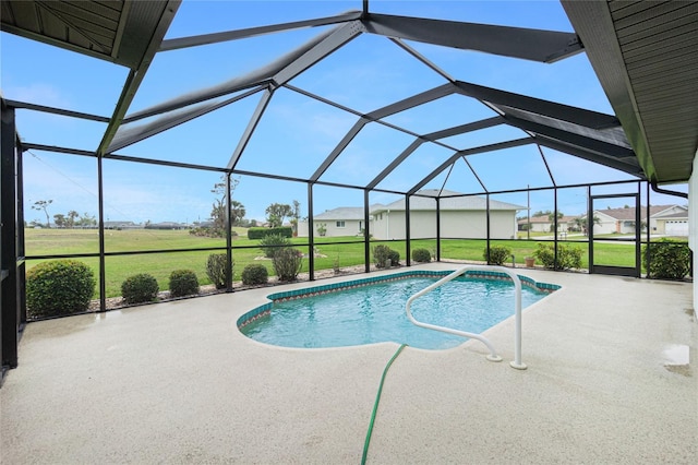 pool with glass enclosure, a yard, and a patio area