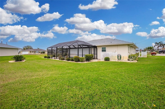 back of house with a lanai, a yard, and stucco siding