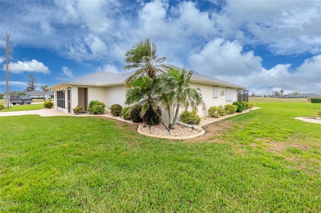 view of side of property with a lawn and stucco siding