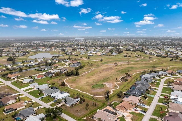 drone / aerial view featuring a residential view, golf course view, and a water view